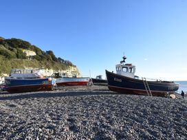 Three boats on a pebble beach at Ellishayes Farm in Combe Raleigh
