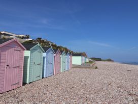 A row of beach huts on a pebbled beach at Ellishayes Farm in Combe Raleigh