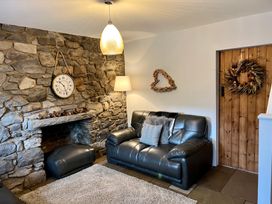 A living room with a sofa and a fireplace at Penderyn Cottage in Aberdare