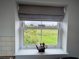 A kitchen window with a teapot on the sill at Penderyn Cottage in Aberdare