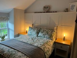 A bedroom with a bed and nightstand at Penderyn Cottage Aberdare