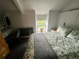 A bedroom with a bed and dressing table at Penderyn Cottage Aberdare