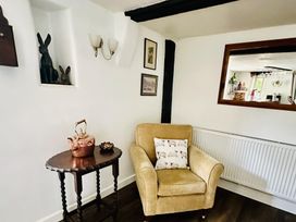 A living room with a chair and a table at The Bark House in Tiverton