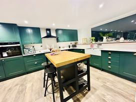 A kitchen with cabinets and an island at The Bark House in Tiverton