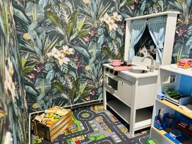 A playroom with a toy kitchen and blocks at The Bark House in Tiverton
