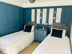A bedroom with two beds and a lamp on a nightstand at The Bark House in Tiverton