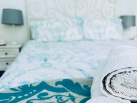 A bedroom with a bed and a towel at The Bark House in Tiverton