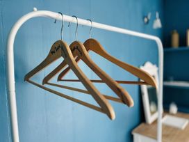 A set of wooden hangers with a blue wall background at The Bark House in Tiverton