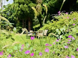 A garden with flowers and a seating area at The Bark House in Tiverton