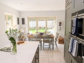 A kitchen with a dining area and a vase of flowers at East View in Cheltenham