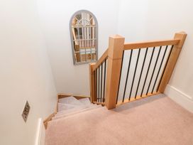 A staircase with wooden handrail and mirror at East View in Cheltenham
