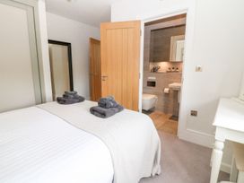 A bedroom with towels on the bed and a bathroom door at East View in Cheltenham