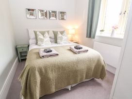 A bedroom with a bed and table at East View in Cheltenham