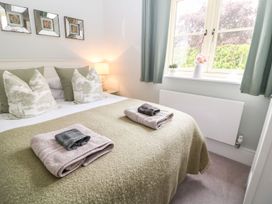 A bedroom with a bed and towels at East View in Cheltenham