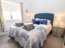 A bedroom with a bed and towels arranged on it at East View in Cheltenham