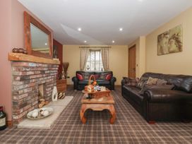 A living room with a fireplace and sofas at Champagne Cottage in Malton