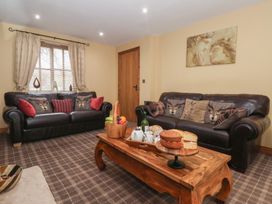 A living room with seating, table, and decorative items at Champagne Cottage in Malton