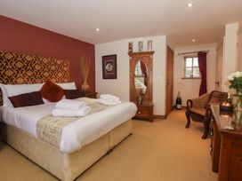 A bedroom with a bed and decorative elements at Champagne Cottage in Malton