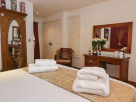 A bedroom with a bed and towels at Champagne Cottage in Malton