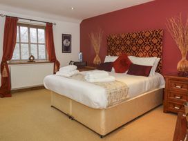 A bedroom with a bed and bedside table at Champagne Cottage in Malton