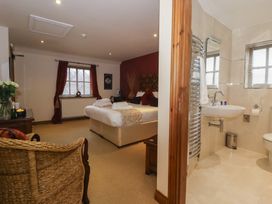 A bedroom with a bed and an adjoining bathroom at Champagne Cottage in Malton