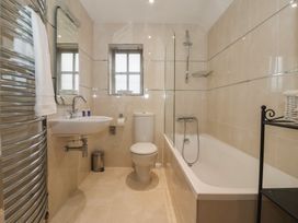 A bathroom with a bathtub and shower at Champagne Cottage in Malton