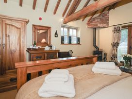 A bedroom with a bed and wooden furniture at Champagne Cottage Malton