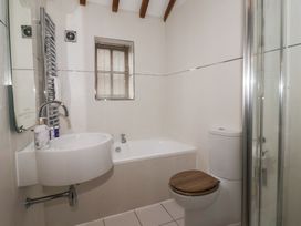 A bathroom with a sink, bathtub, toilet, and shower at Champagne Cottage in Malton