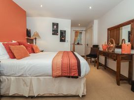 A bedroom with a bed and a dressing table at Champagne Cottage in Malton