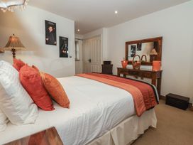 A bedroom with a bed and nightstand at Champagne Cottage in Malton