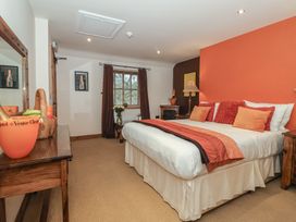 A bedroom with a bed and nightstand at Champagne Cottage in Malton