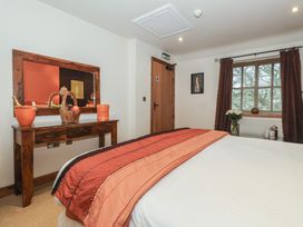 A bedroom with a bed and a mirror at Champagne Cottage in Malton