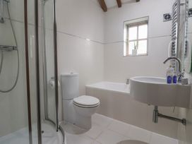 A bathroom with shower, toilet, bathtub, and sink at Champagne Cottage in Malton