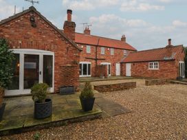 An outdoor area with brick buildings and gravel ground at Champagne Cottage in Malton