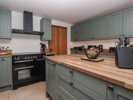 A kitchen with cabinets and an island at Champagne Cottage Weaverthorpe