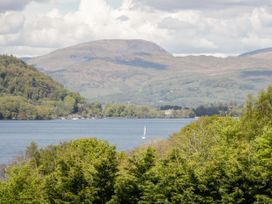 A view of a lake with mountains and trees at 6 Waterside, White Cross Bay, Troutbeck Bridge