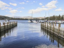 A view of boats docked at a pier with mountains in the background at 6 Waterside White Cross Bay Troutbeck Bridge