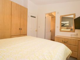 A bedroom with a wardrobe and a mirror at 6 Waterside, White Cross Bay near Windermere