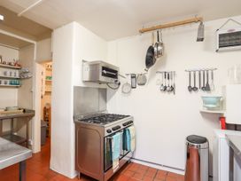 A kitchen with a stove and utensils at Angorfa Apartment in Abersoch