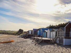 Beach huts along the shoreline at Angorfa Apartment in Abersoch