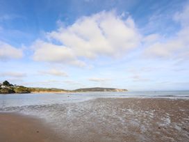 A beach scene with water and sand at Angorfa Apartment in Abersoch