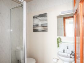 A bathroom with a shower, toilet, and sink at Angorfa Apartment in Abersoch