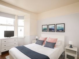 A bedroom with a bed and a television at Angorfa Apartment in Abersoch