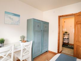 A bedroom with a wardrobe and table at Angorfa Apartment in Abersoch