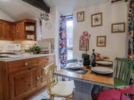 A kitchen with a dining area at Honeypot Cottage Whitchurch Canonicorum