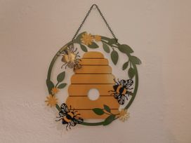 A decorative wall hanging featuring a honeycomb and bees at Honeypot Cottage Whitchurch Canonicorum