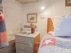 A bedroom with a bed and nightstand at Honeypot Cottage Whitchurch Canonicorum