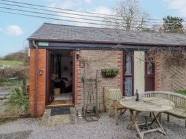 An outdoor seating area with a table and chairs at Honeypot Cottage Whitchurch Canonicorum