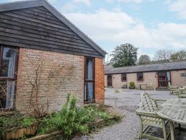 An outdoor area with buildings and seating at Honeypot Cottage Whitchurch Canonicorum