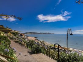 A view of the beach and sea with steps and plants at Honeypot Cottage in Whitchurch Canonicorum